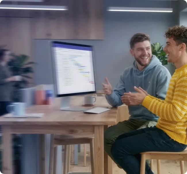 An image of two men sitting at an office table and talking
